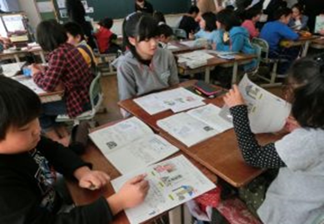 教室で小学生が班になり話し合っている様子